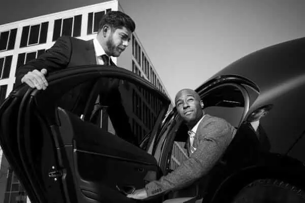 Two business men getting out of a car.
