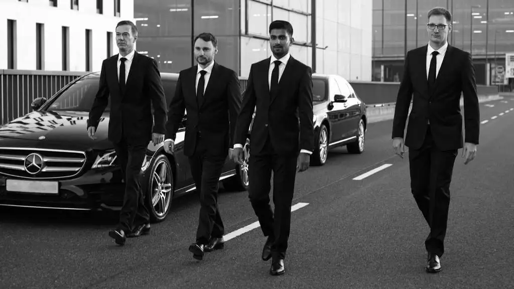 A group of men in suits walking down the street.