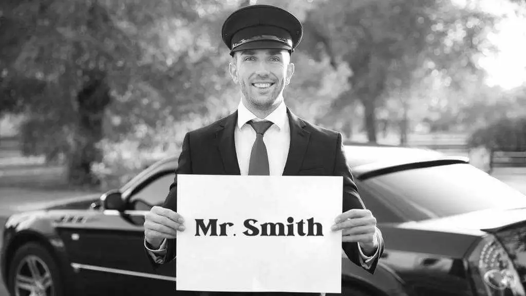 A man holding a sign that says mr smith.