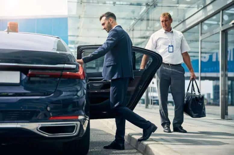 Two businessmen arriving at an airport in Brooklyn, using Luxury Airport Transportation service.