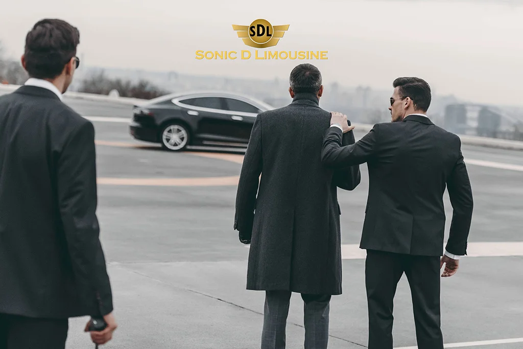 Sonic D Limousine Three men in suits standing next to a black tesla.