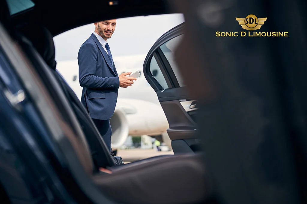 Sonic D Limousine A man in a suit standing in the door of an airplane.
