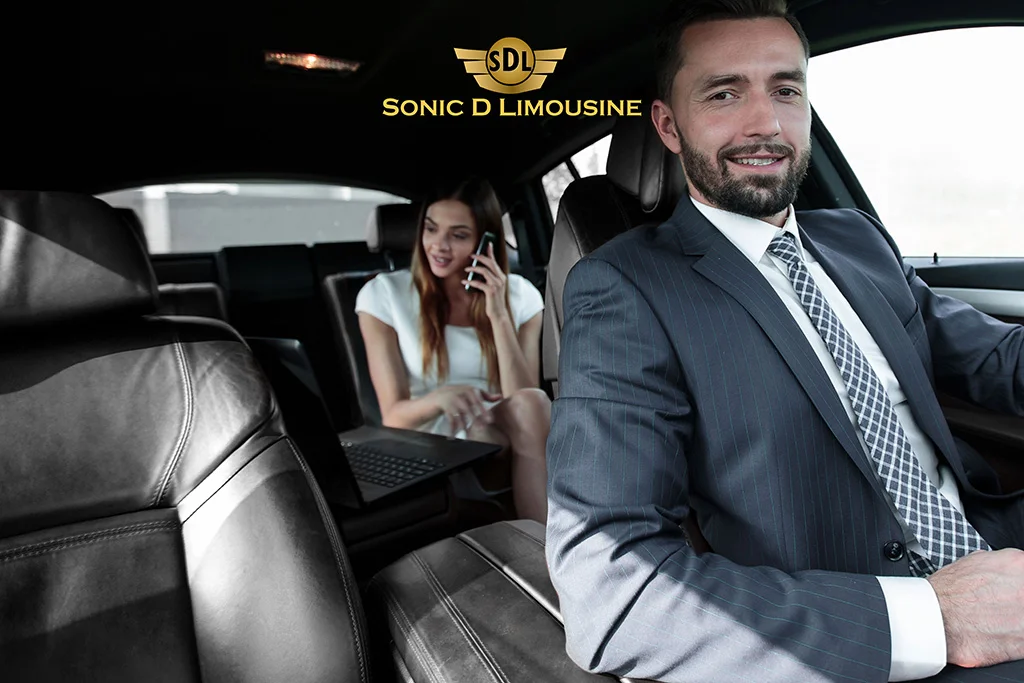 Sonic D Limousine A man and woman sitting in the back seat of a car.